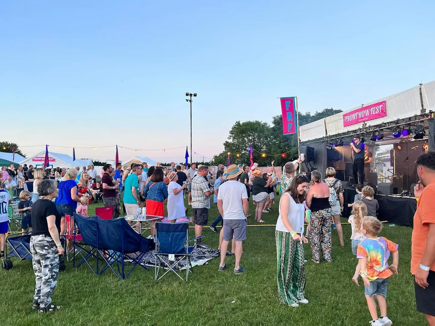 Crowd enjoying live music at Front Row Fest under an Oxfordshire evening sky